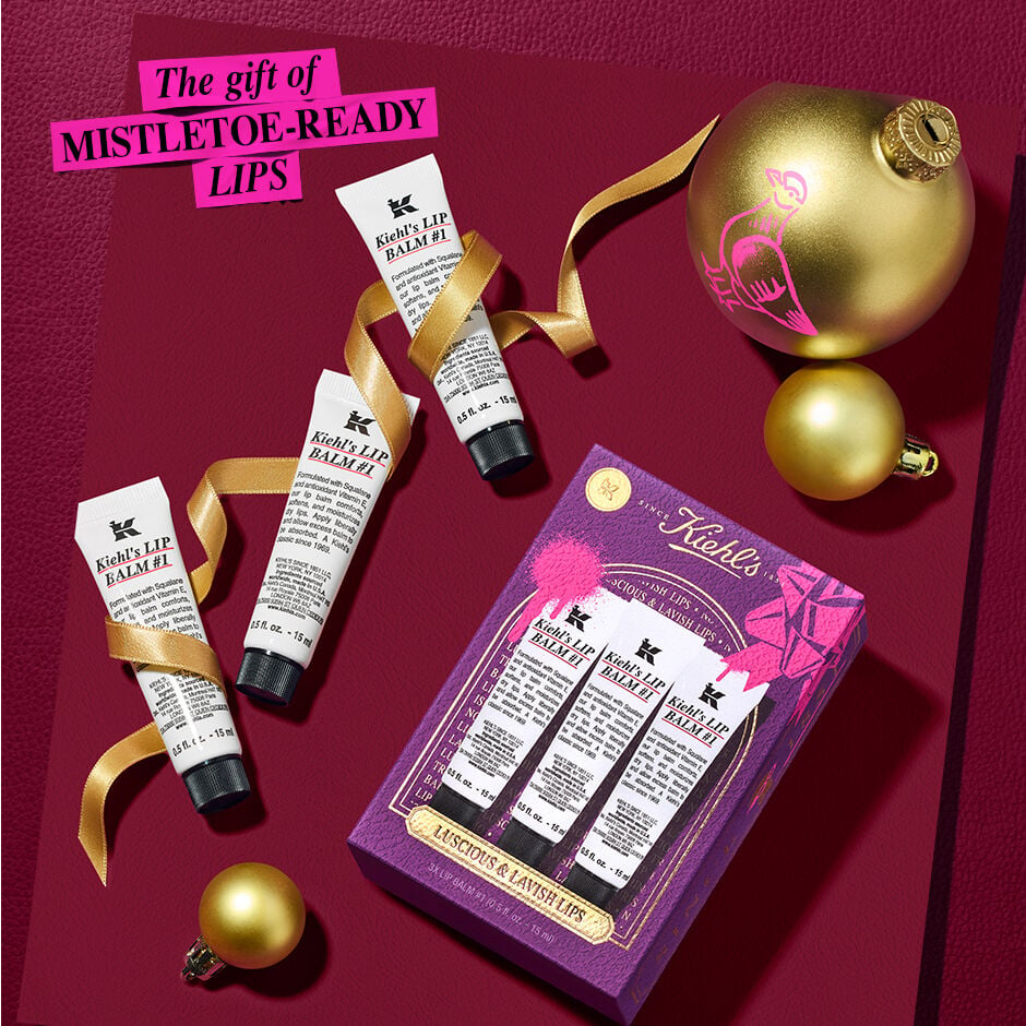 lip balms next to gift box with ornaments and tinsel surrounding. the gift of mistletoe ready lips 