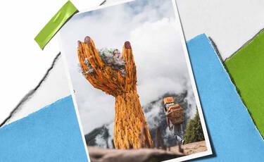Large woven hand sculpture holding plastic waste against misty mountains, representing Kiehl’s cleanup and plastic renewal initiatives.​