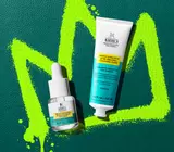 acne spot treatment and acne cleanser on green leather background