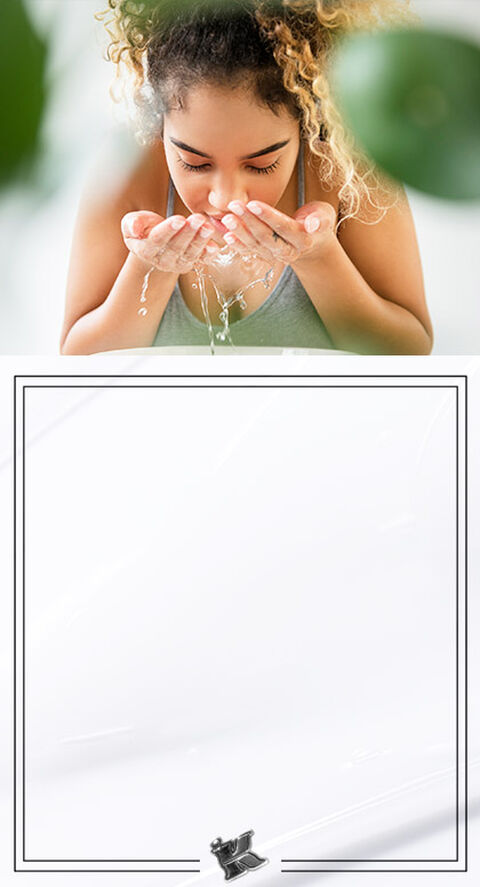 A woman leaning over a sink and washing her face