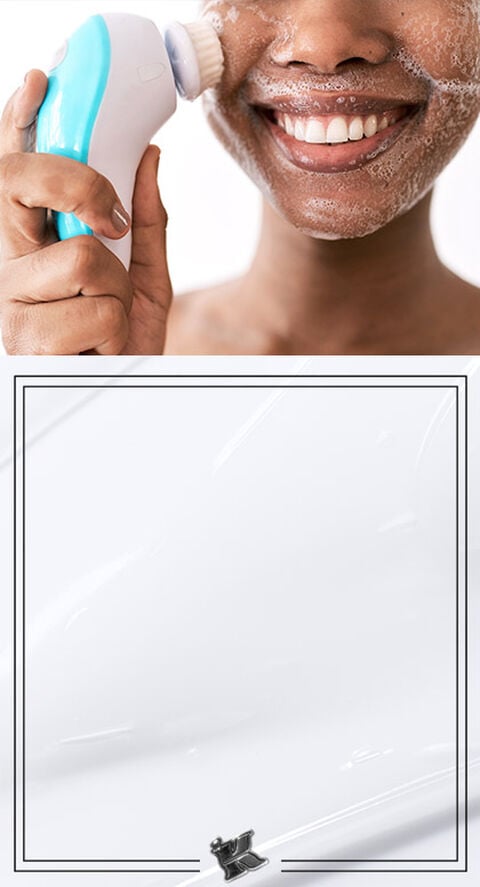 A woman using an electric facial cleansing brush