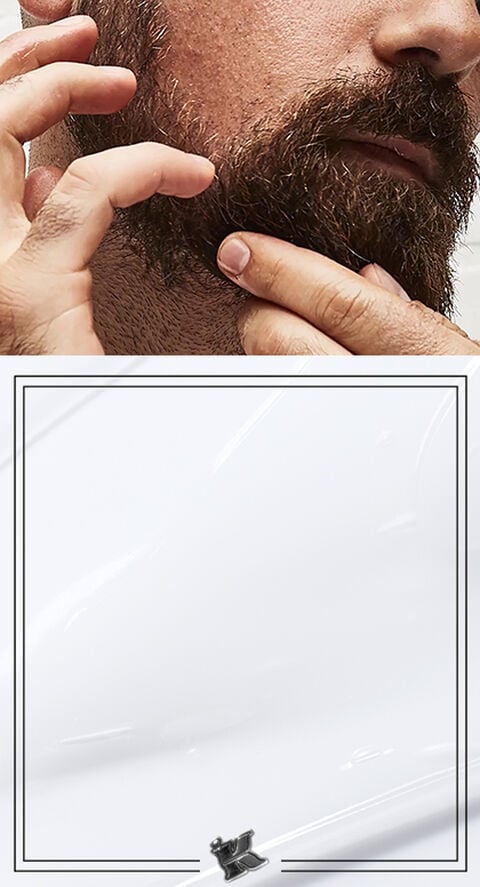 A man running his fingers through his beard.