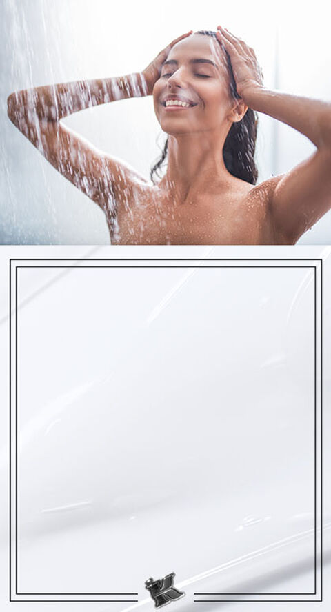 A shot of someone standing under a waterfall, letting the water run through their hair.