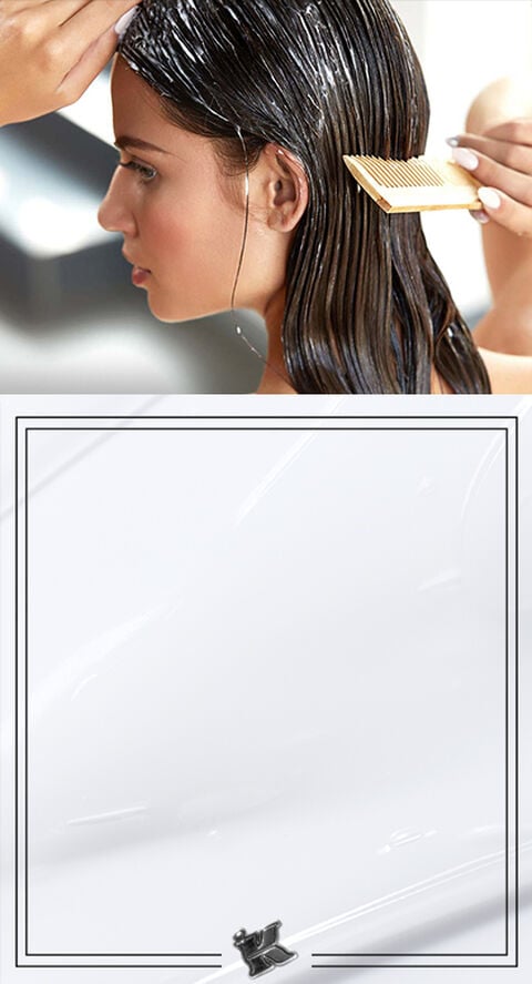 A person combing a conditioner through their hair