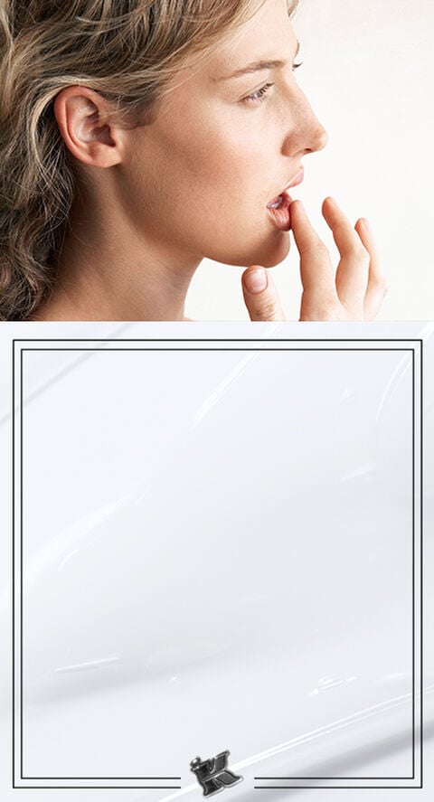 A photo of someone lightly touching their lips.
