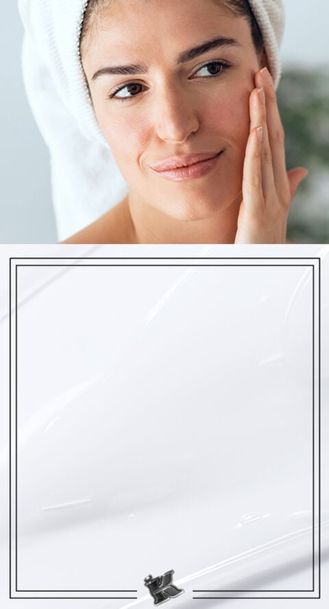 A woman applying moisturizer to her face