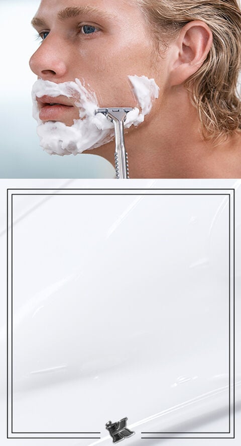 A man shaving his face with shaving cream