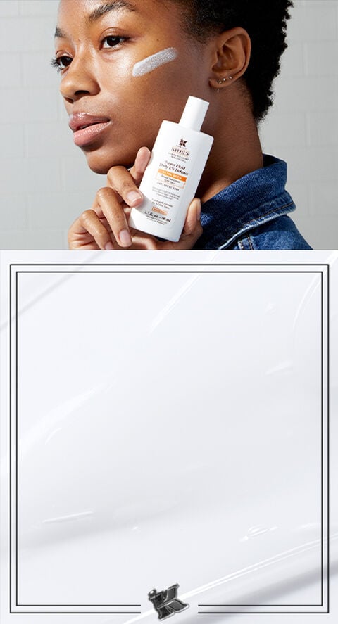 A person holding Kielh's mineral sunscreen