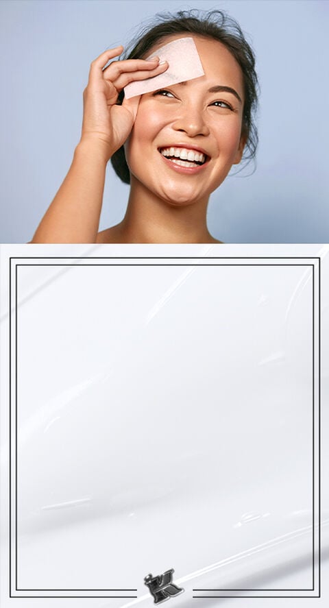 A person blotting their face with a face wipe