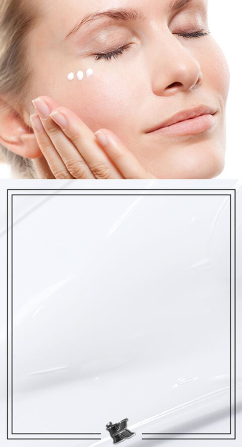 A woman rubbing a lotion face cream into her face.