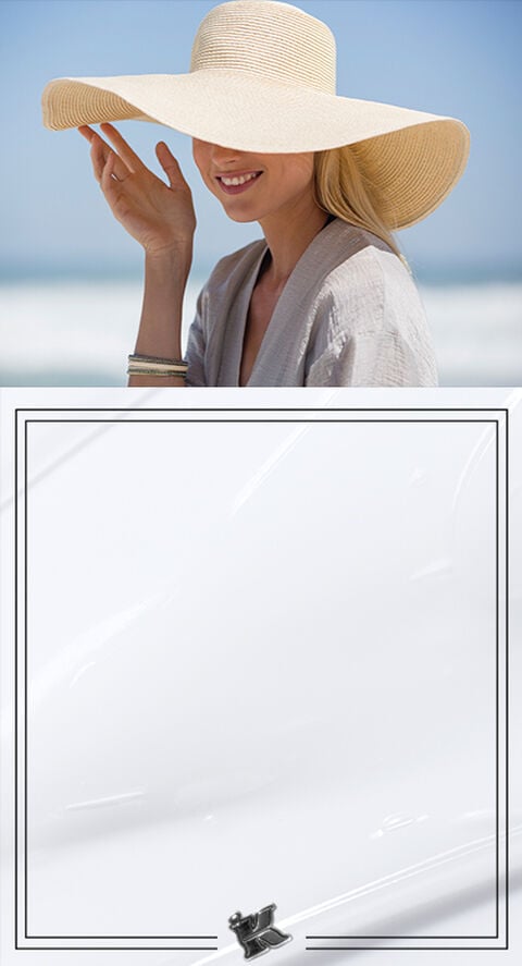 A WOMAN IN A FLOPPY SUN HAT ON A BEACH
