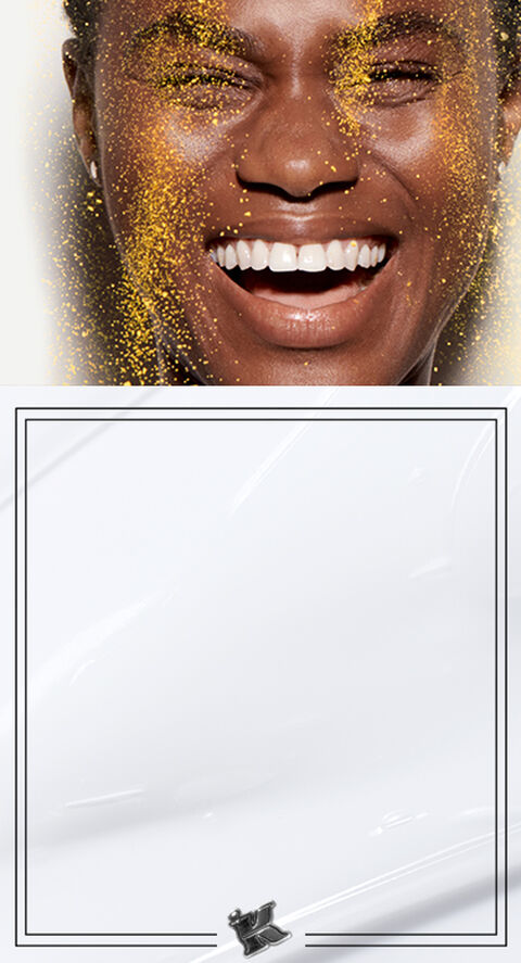 A woman smiling with face glitter running down face