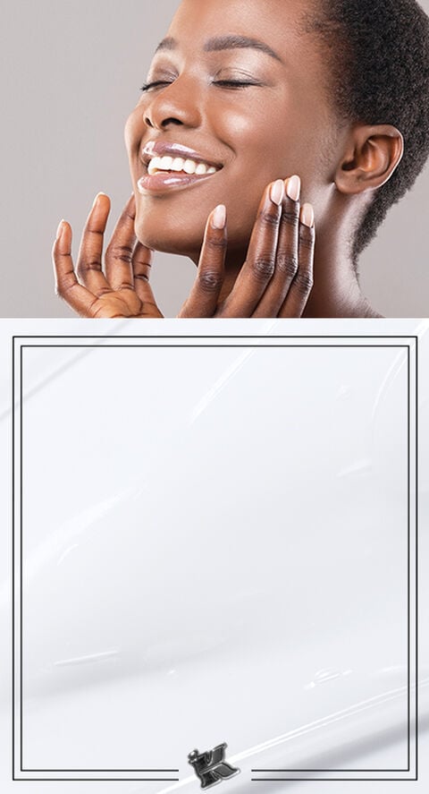 A dark skinned woman touching her face
